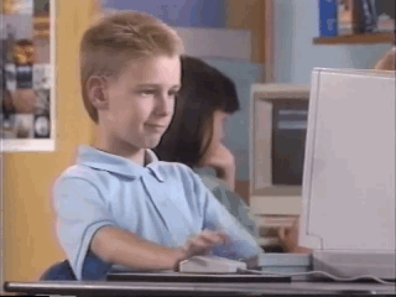A Child working on a computer smiling